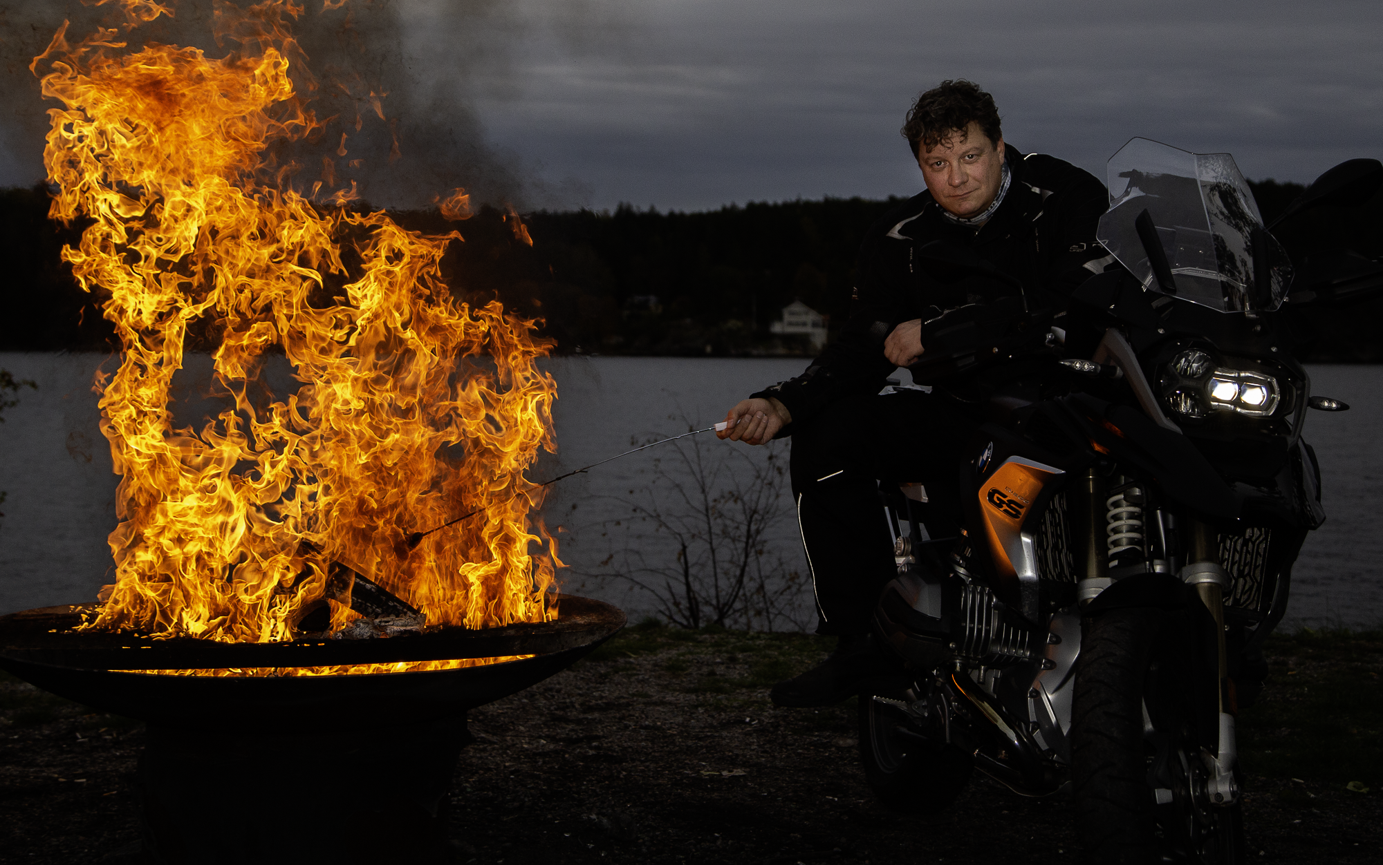 Grillmästare Peter Watz sitter på en BMW R1200GS och grillar korv. 