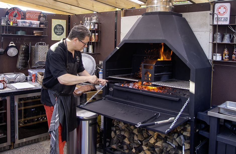 Grillmästare Peter Watz förbereder den vedeldade Braaien för en fotografering med Länsförsäkringar Hälsoportal