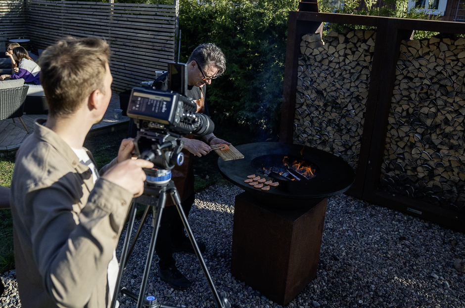 Close up filmning när filmaren för Swedish Match och Nitedals zoomar in OFYRen där Peter Watz lägger lax på stekplattan