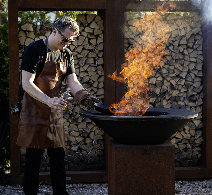 Grillmästare Peter Watz showar med offren och skapar en hög eldslåga från grillen